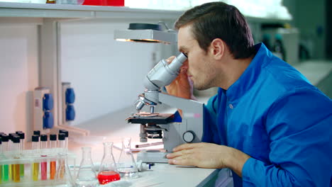 Male-scientist-doing-microscope-research.-Man-scientist-looking-microscope